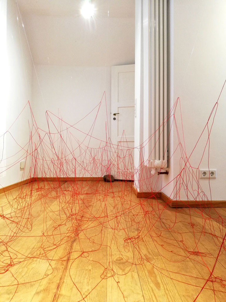 ANJA ASCHE. Oberfläche – Installation, Messingscheibe, Messingstab, roter Faden, Masse variabel, 2021. Surface – Installation, brass disc, brass rod, red thread,
   mass variable, 2021 