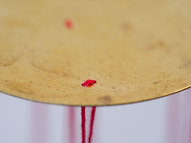 Anja Asche – Oberfläche – Installation, Messingscheibe, Messingstab, roter Faden, Masse variabel, 2021. Surface – Installation, brass disc, brass rod, red thread,
mass variable, 2021