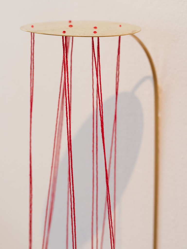 ANJA ASCHE. Oberfläche – Installation, Messingscheibe, Messingstab, roter Faden, Masse variabel, 2021. Surface – Installation, brass disc, brass rod, red thread,
   mass variable, 2021 