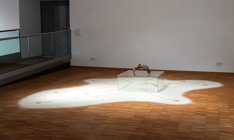 ANJA ASCHE – Entfaltung. 
Installation – Holzstück, Wachs, Fäden, Nadeln, Sand, Podest, ca. 400 x 350 cm, 2023